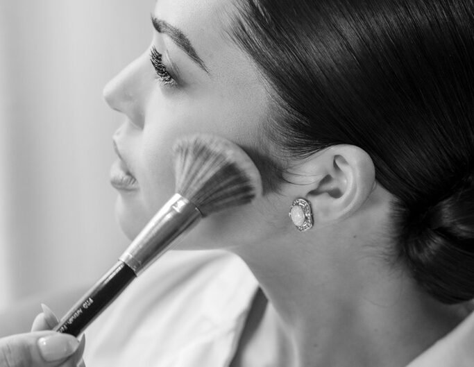 A bride receiving the final touch of makeup before her wedding