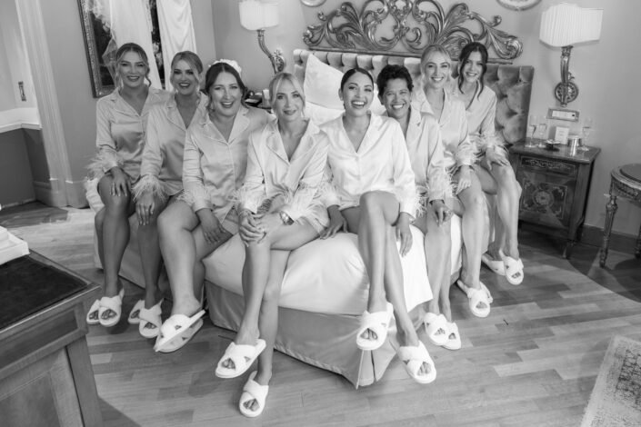 A group of bridesmaids joyfully stand together, overlooking Lake Como and Grand Hotel Tremezzo