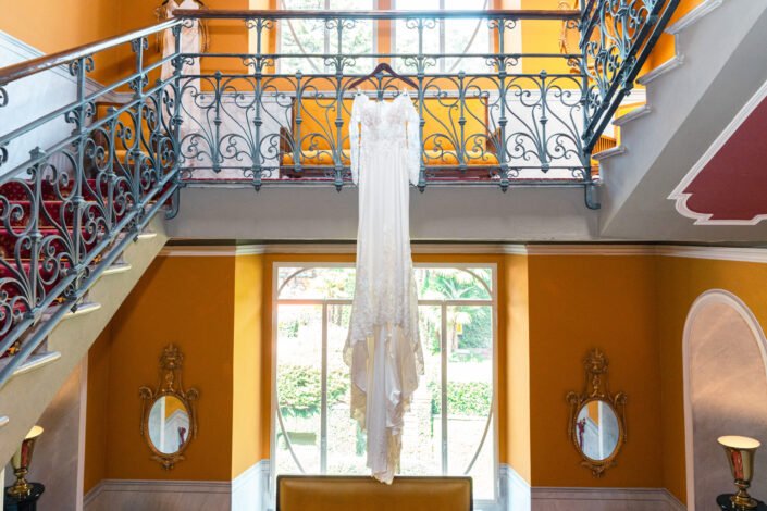A close-up of a bride's elegant wedding dress against the backdrop of Lake Como and the Grand Hotel Tremezzo